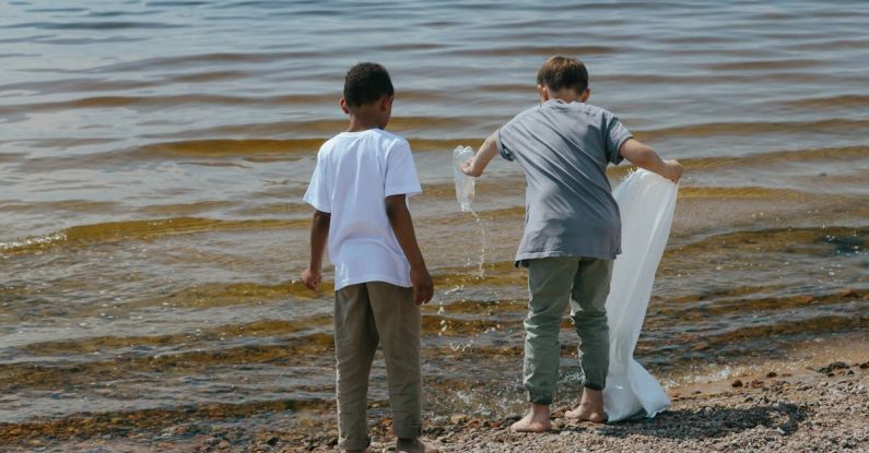Ocean Cleaning - Young Boys Holding a Sack and Plastic Bottle Standing on Seashore