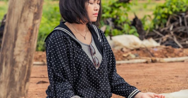 Yoga Meditation - Woman Sitting Outside with Eyes Closed and Meditating