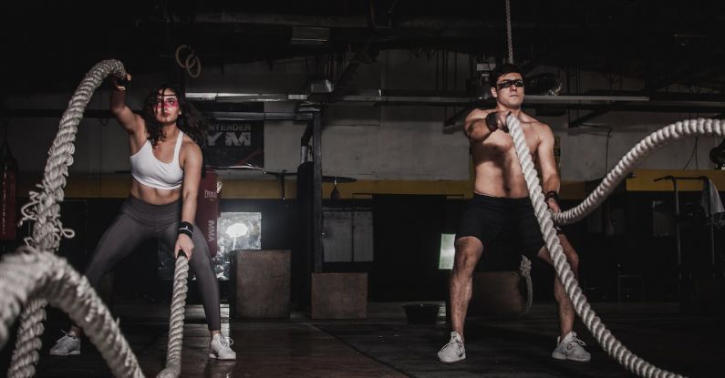 CrossFit Training - Man And Woman Holding Battle Ropes