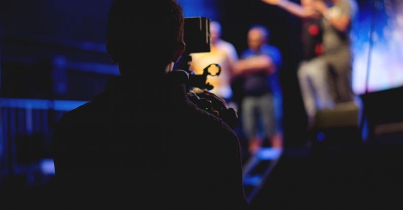 Film Set - Man Standing on Stage Holding Microphone