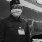 Hyperloop Train - A woman in a face mask standing next to a train