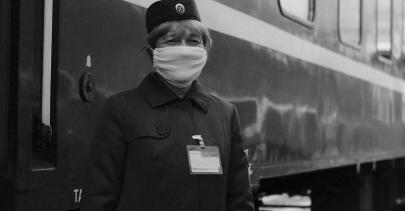 Hyperloop Train - A woman in a face mask standing next to a train