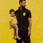 Father Child - A man and a child standing in front of a yellow wall