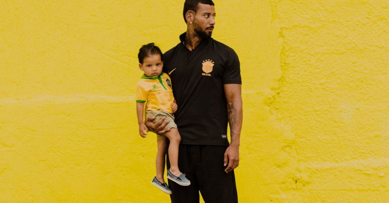 Father Child - A man and a child standing in front of a yellow wall
