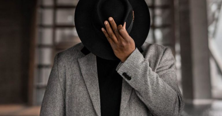 Good Posture - Person in Gray Coat Holding Black Hat