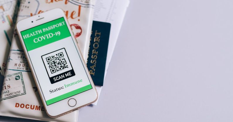 Immune Boost - Smart Phone with a Health Passport App and Travel Documents Lying on a Table