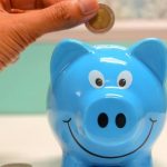 Money Saving - Person Putting Coin in a Piggy Bank