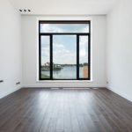 Apartment Space Saving - Interior of modern spacious light room with wooden laminate floor white walls and panoramic windows