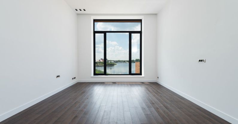 Apartment Space Saving - Interior of modern spacious light room with wooden laminate floor white walls and panoramic windows